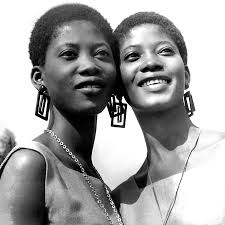 Two women laughing together in contemporary tailoring with subtle ankara detail